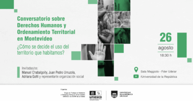 Afiche horizontal de fondo blanco. En el sector izquierdo se presenta la información principal del evento y, a la derecha, una composición de fotografías en blanco y negro de varias manos levantadas, algunas superpuestas con transparencias verdes. Pequeños cuadrados verdes completan la composición. El texto principal dice: “Conversatorio sobre Derechos Humanos y Ordenamiento Territorial en Montevideo”. Debajo aparece la pregunta: “¿Cómo se decide el uso del territorio que habitamos?” Más abajo se lee: “Invitadas/os: Manuel Chabalgoity, Juan Pedro Urruzola, Adriana Goñi y representante organización social”. En el sector derecho se destaca la fecha y hora: “26 agosto, 18:30 h”. En la parte inferior se indica el lugar: “Sala Maggiolo, Edificio Central de la Universidad de la República”, junto al ícono de ubicación. También aparece un ícono de YouTube seguido de “/Universidad de la República”. Al pie del afiche se informa que organiza el “Grupo de Trabajo de Ambiente y Derechos Humanos de la Cátedra UNESCO de DDHH de la Udelar”. Se incluyen los logotipos de la Cátedra UNESCO de Derechos Humanos de la Universidad de la República y de la Universidad de la República Uruguay.